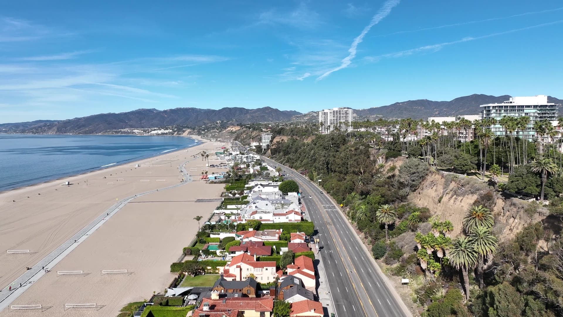 Aerial view of a coastline meeting dense low-rise development.